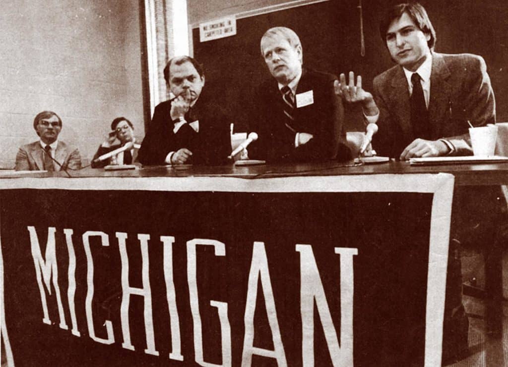 vintage photo of three men at a seated podium 