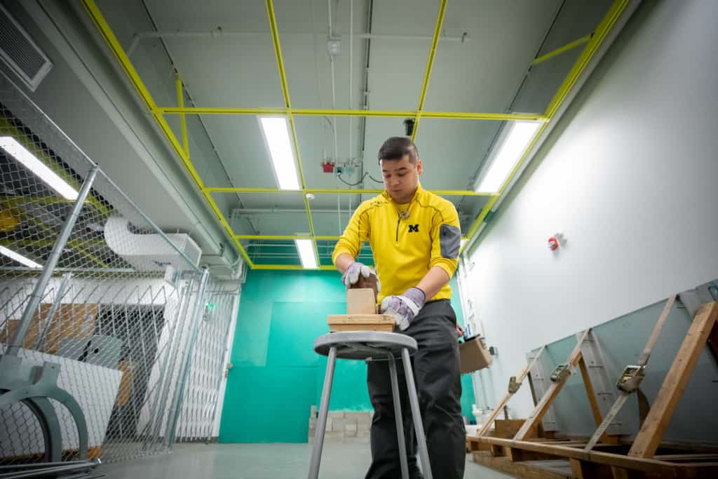 researcher holding a block on a stool in the lab