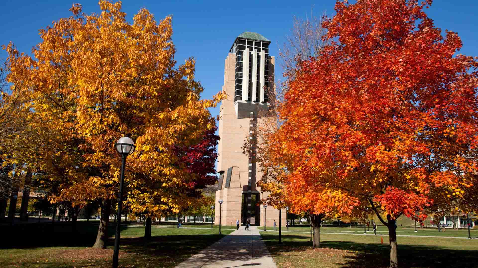 a brick tower and two autumn trees