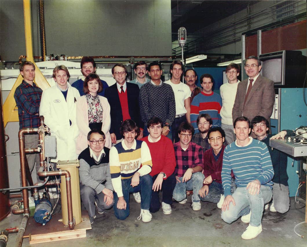 group of people standing in a laboratory in the 80s