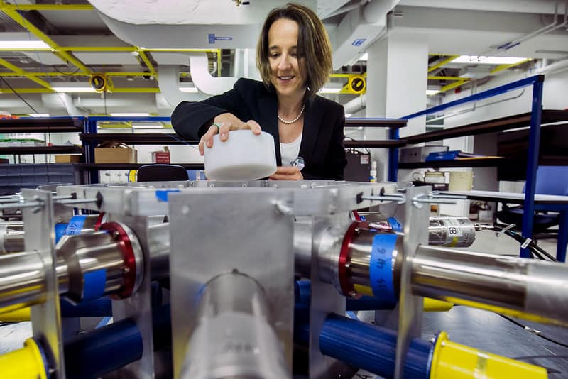 woman placing large white disk into machinery