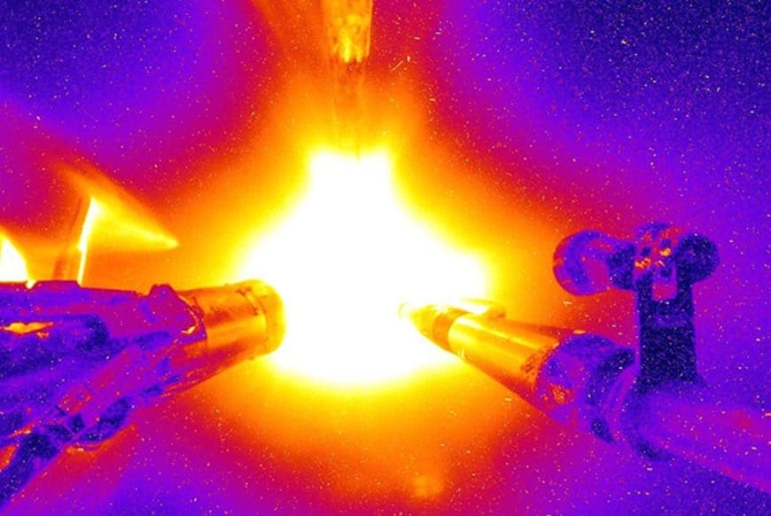 two lasers blasting a large bright orb