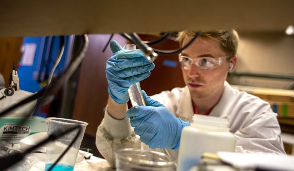 a person wearing blue gloves and working in the lab