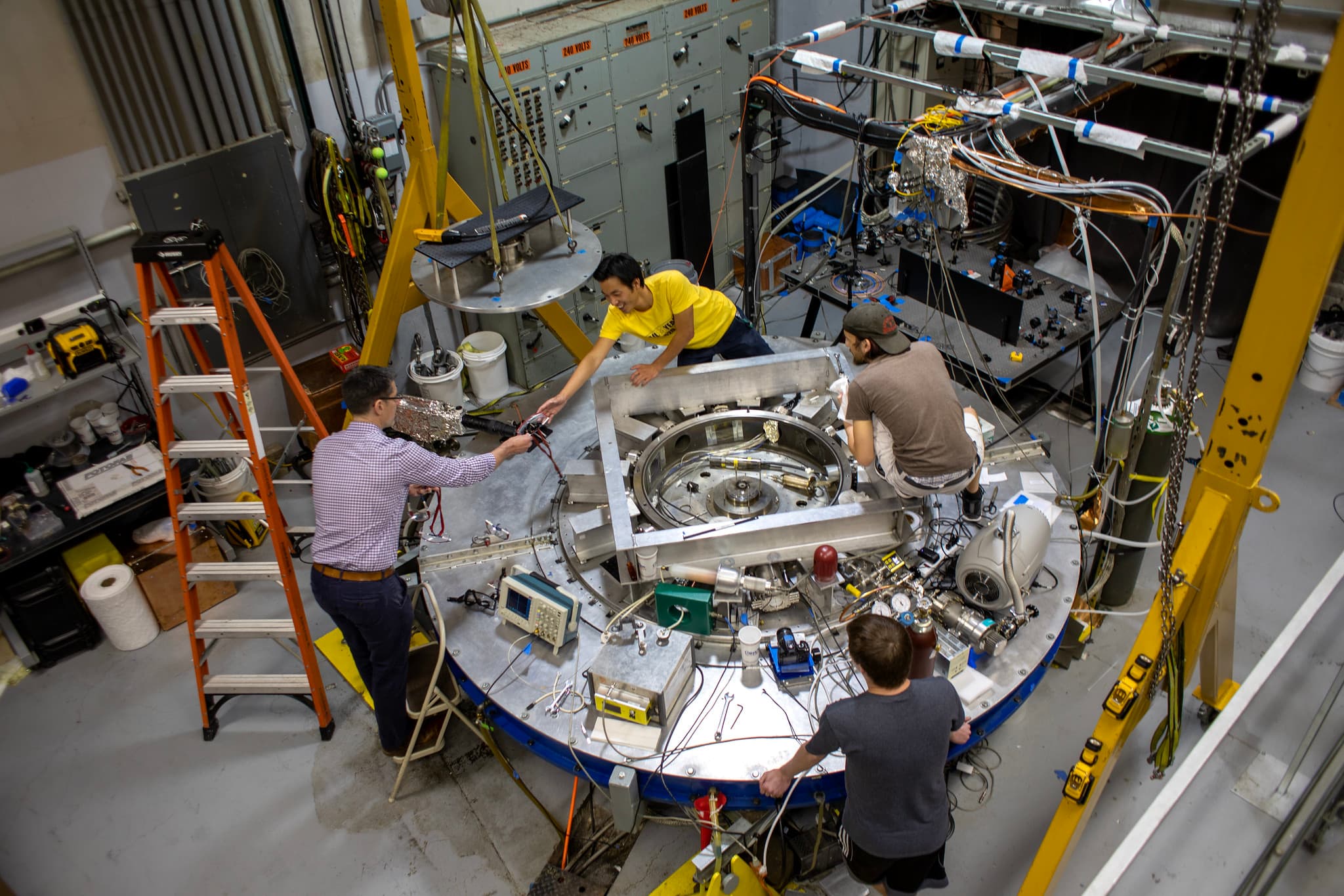 four people working around a large piece of machinery