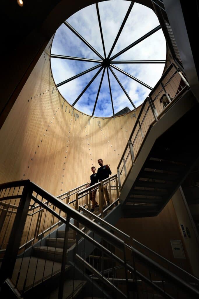 a teacher and a student walking down a staircase through a sundial