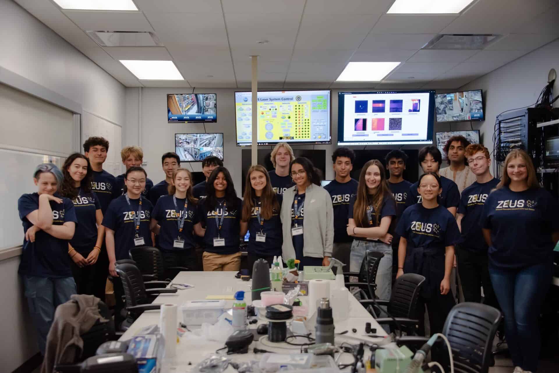 a group of students wearing "ZEUS" tshirts poses together