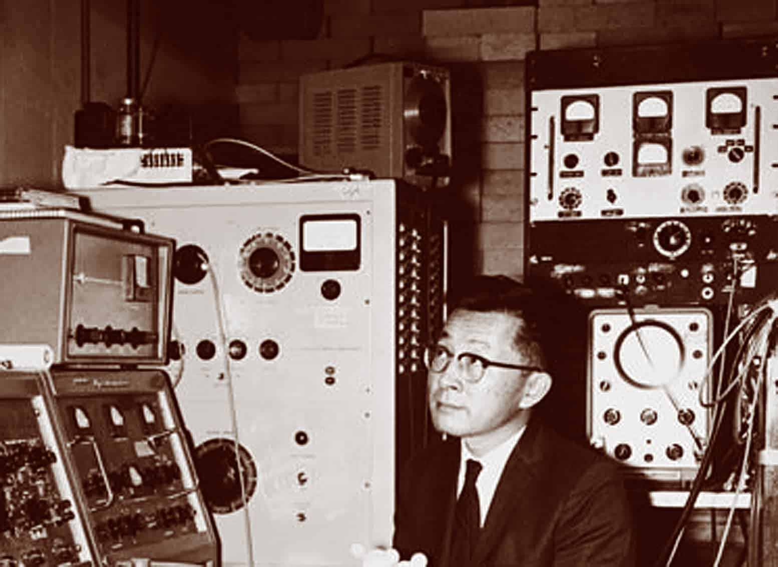 man in suit sitting in front of equipment