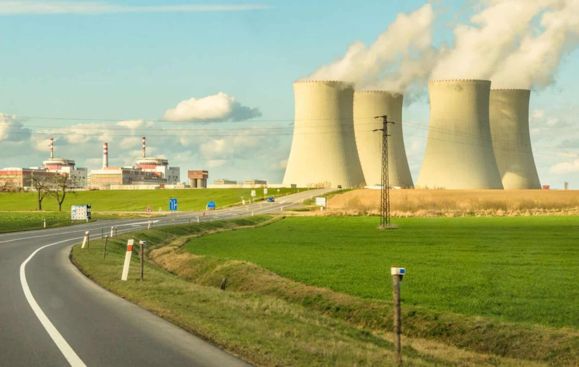 a nuclear power plant behind a field and a country road