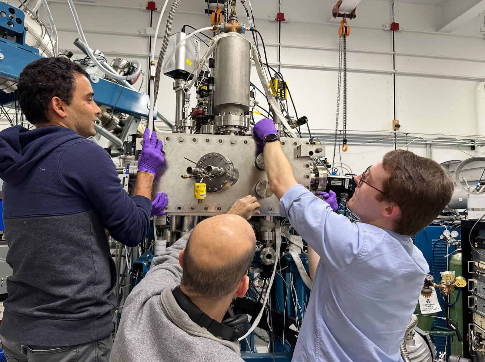 three men working on a piece of equipment